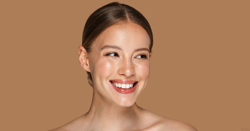 Smiling woman looking to the right, with a cheerful expression and soft lighting highlighting her face. (MODEL)